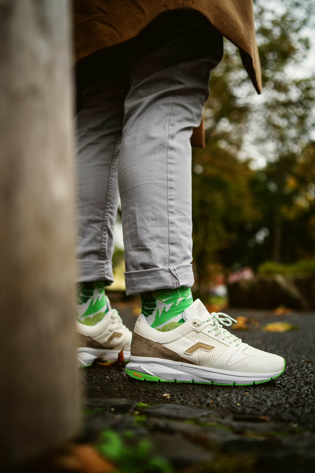 person in gray pants wearing green and white nike sneakers