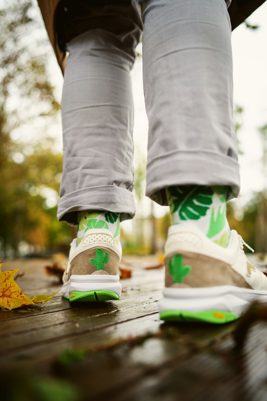 person in gray pants wearing green and white nike sneakers