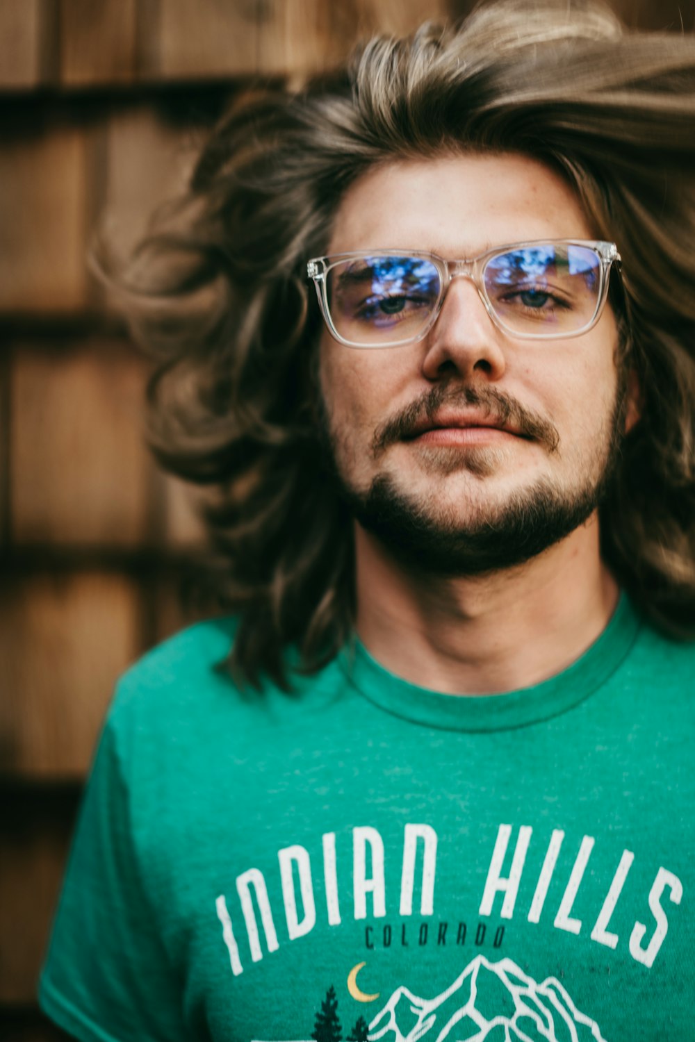 man in green crew neck shirt wearing black framed eyeglasses