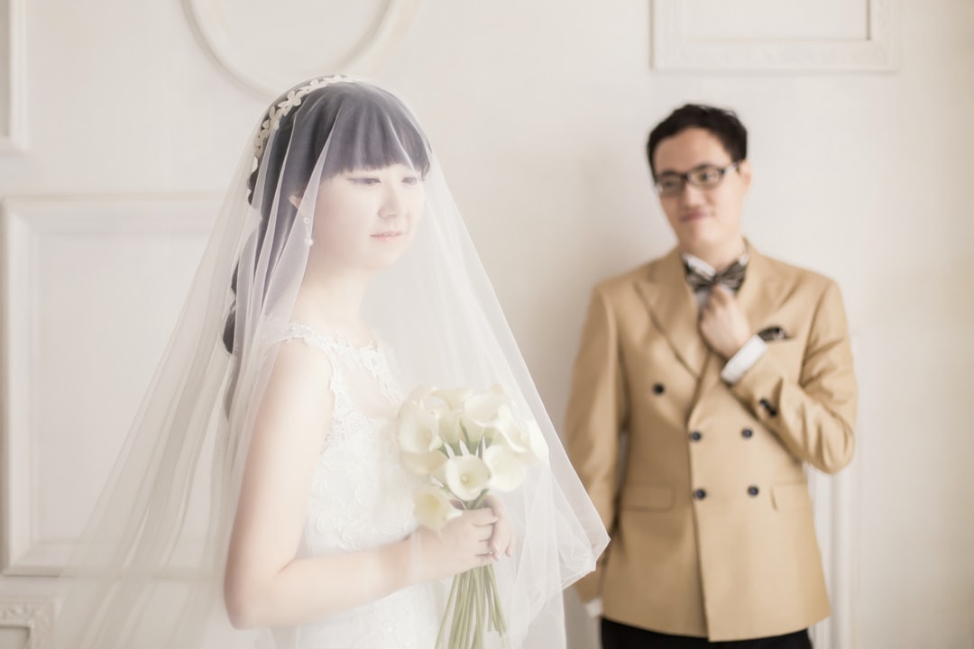 man in brown suit jacket and woman in white wedding dress