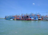 Colorful fishing boats docked at Bayahibe beach under a bright blue sky.