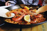 Close-up of a vibrant saffron paella steaming in a traditional pan.