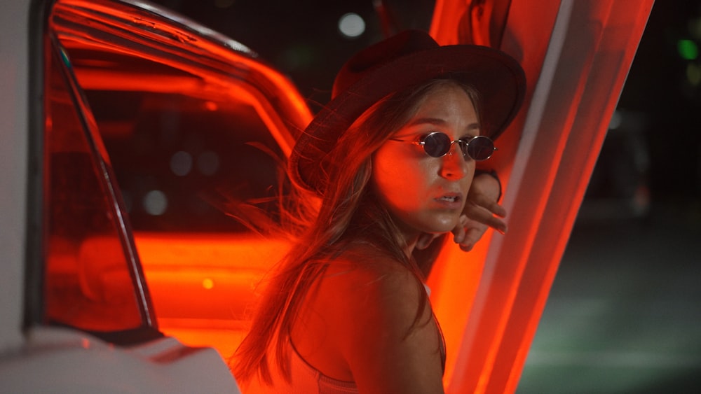 woman in black sun hat and orange tank top