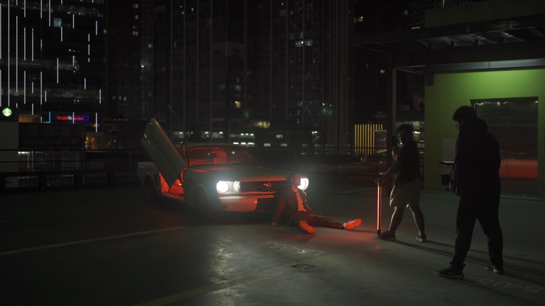 man in black jacket and pants standing on sidewalk during night time