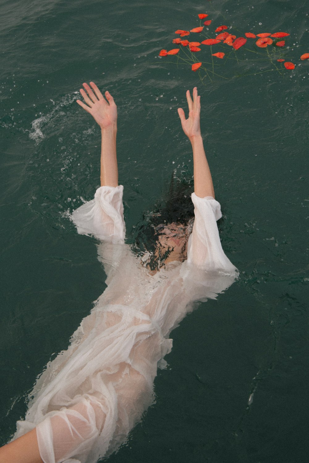 donna in vestito bianco sdraiata sull'acqua