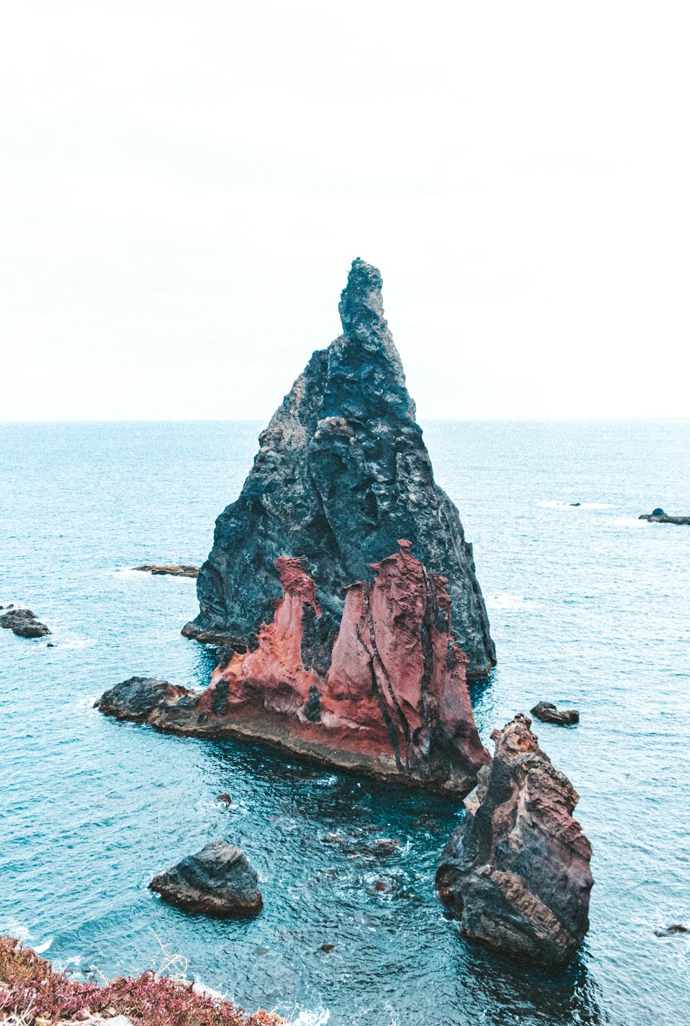 brown rock formation on body of water during daytime