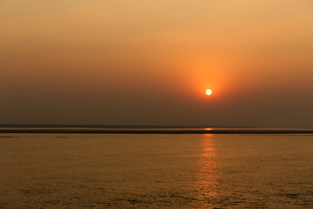 calm sea under orange sky during sunset