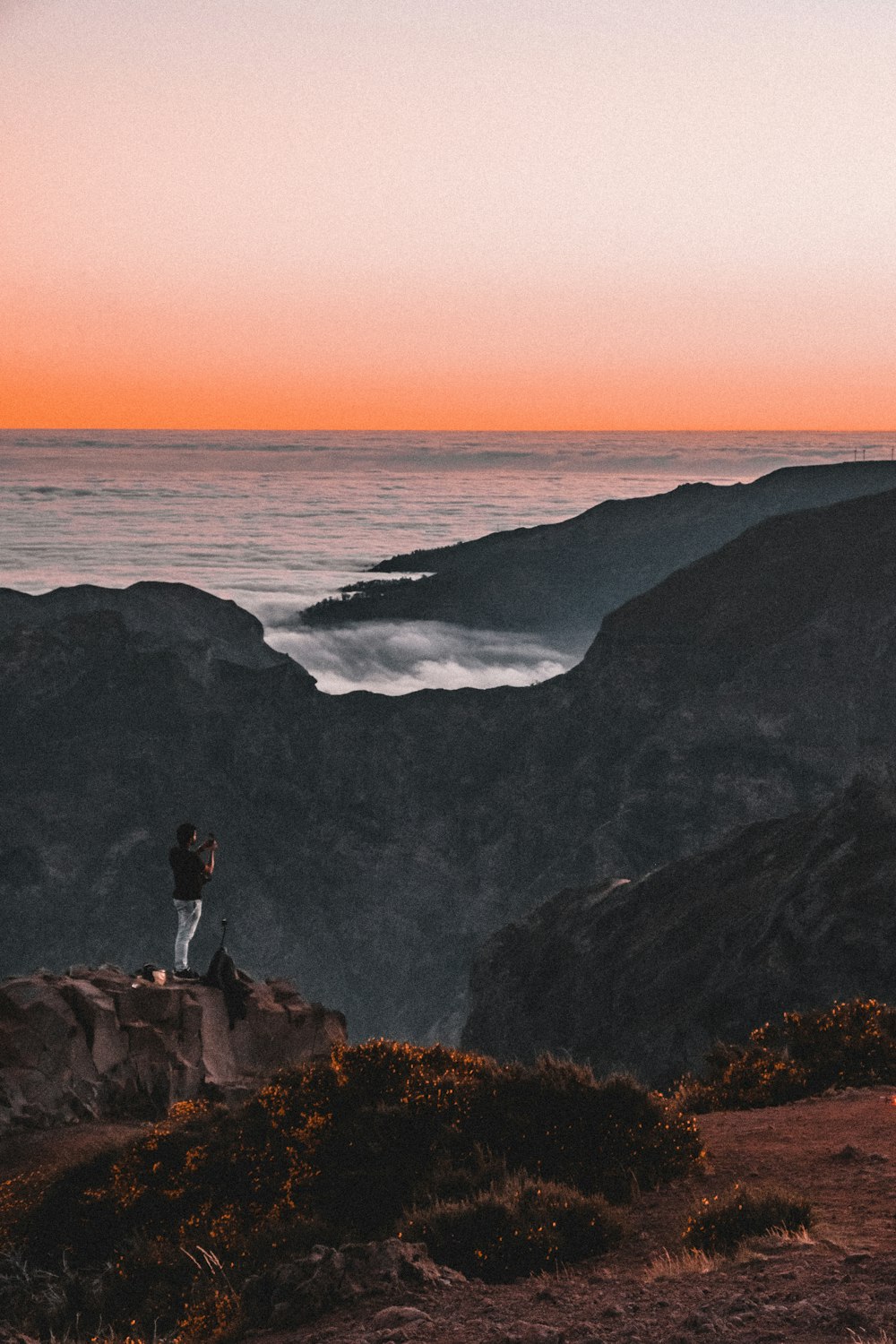 person standing on rock near sea during daytime