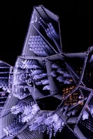 Robot assembling a crystal-clear, glowing digital structure with electric cyan and neon purple mesh gradients in the background.