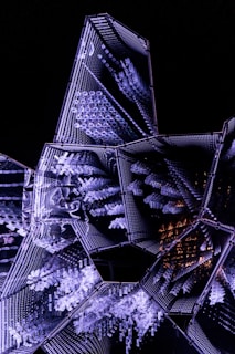 3D robot building a crystal-clear digital structure illuminated by neon purple and electric cyan lights