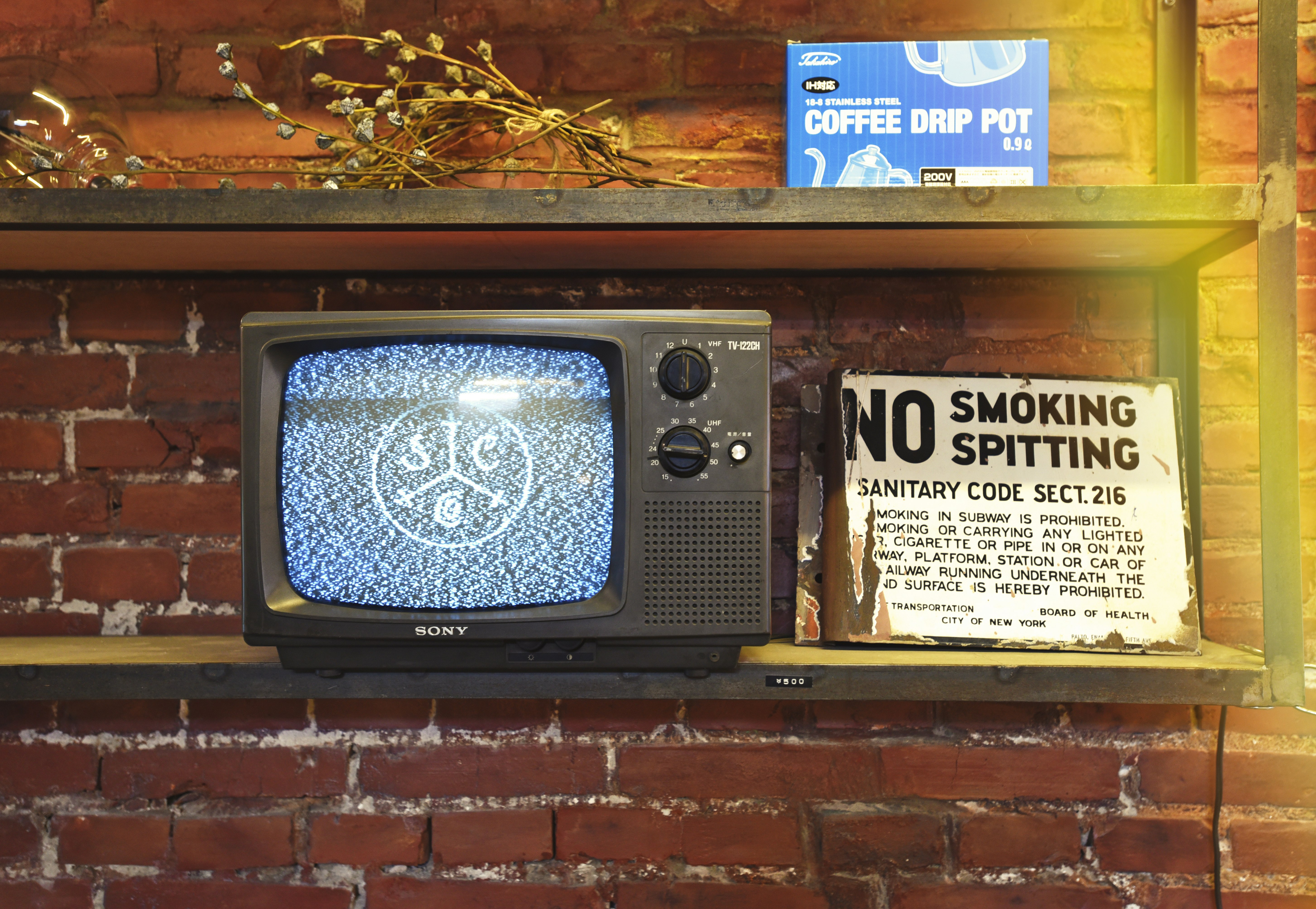 black crt tv on brown brick wall