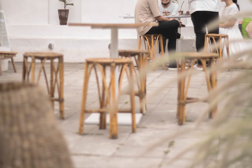 man in white dress shirt sitting on brown wooden chair