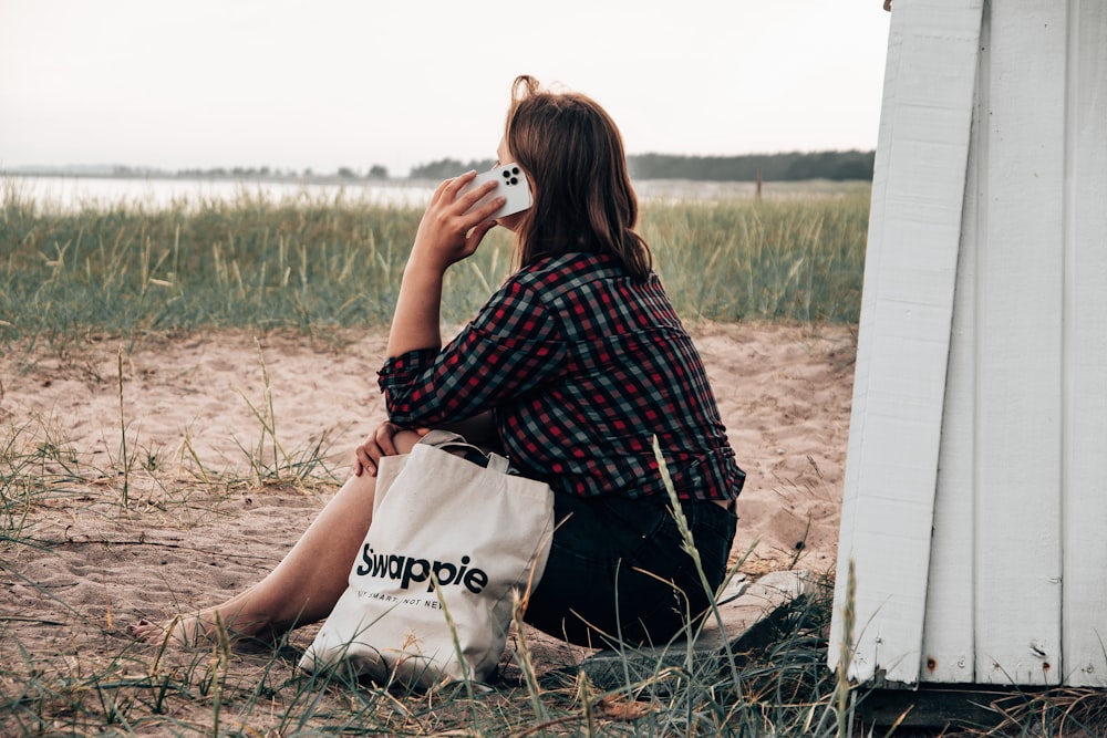 woman in black and white checkered dress sitting on white plastic bag