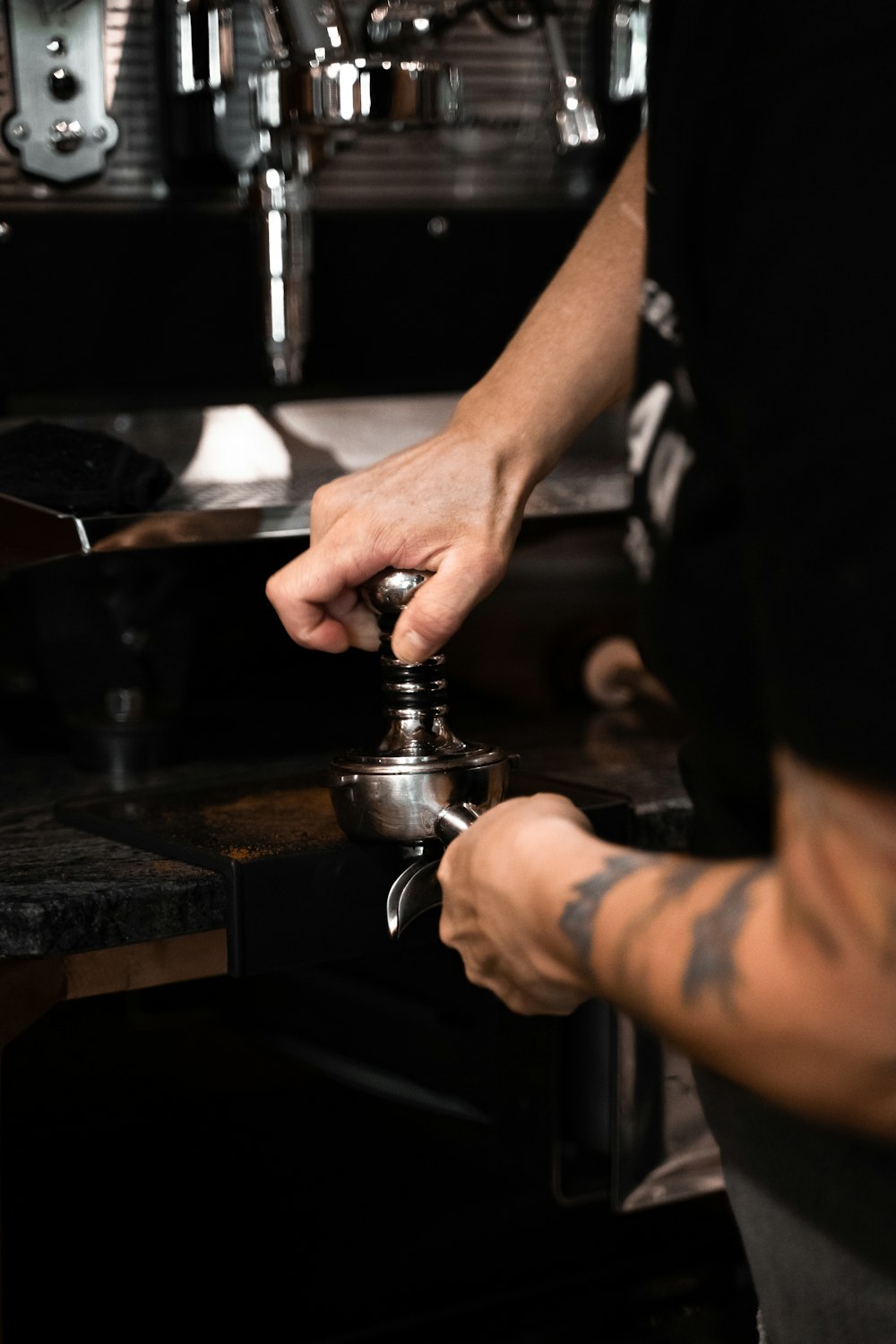 person holding silver and black coffee maker