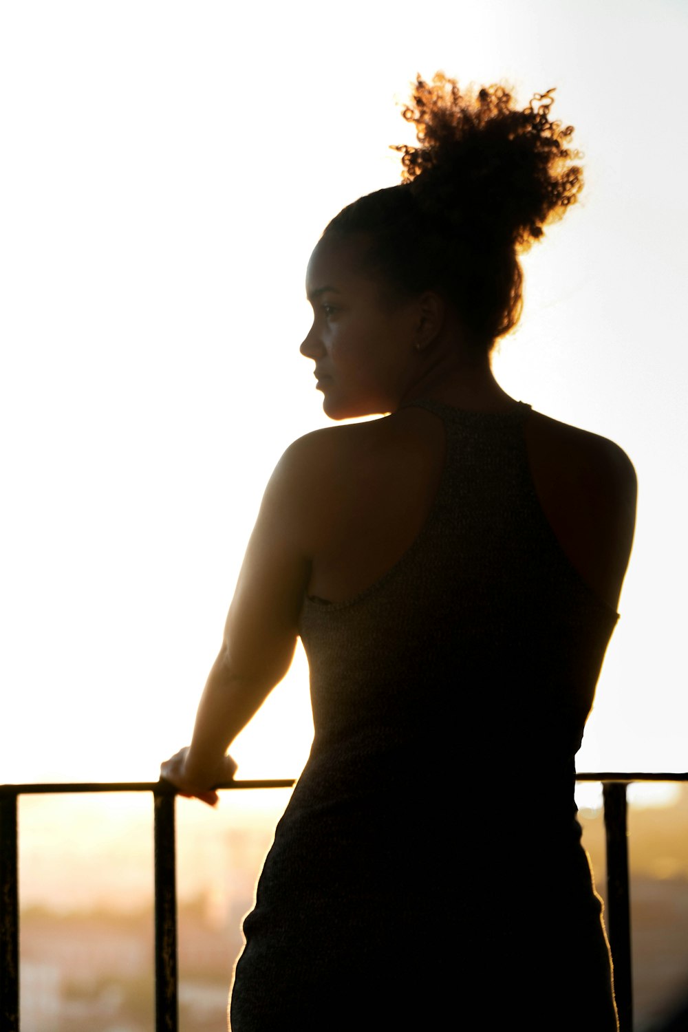 woman in black tank top standing near railings