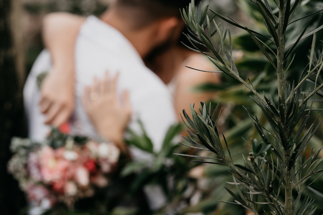 woman in white dress holding red and white flowers