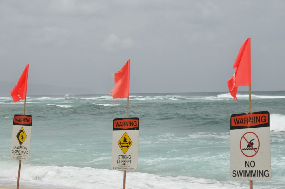 Rote und weiße Flagge am Strand tagsüber