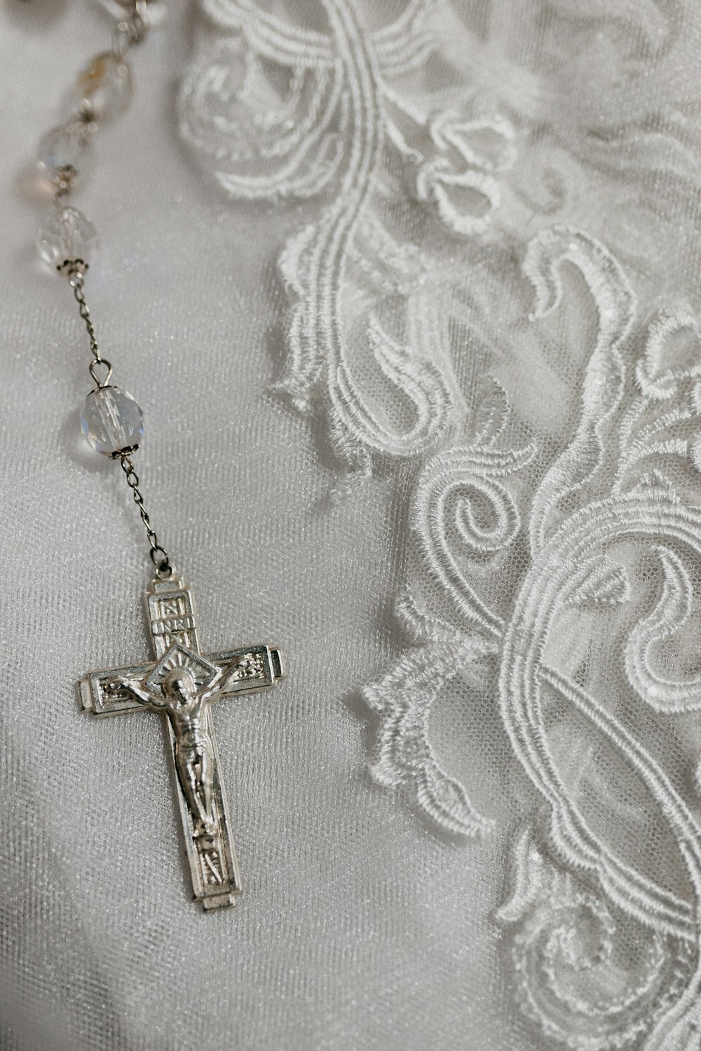 colar pingente da cruz do ouro no têxtil branco