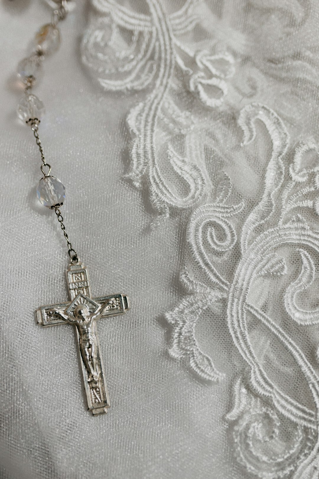 gold cross pendant necklace on white textile