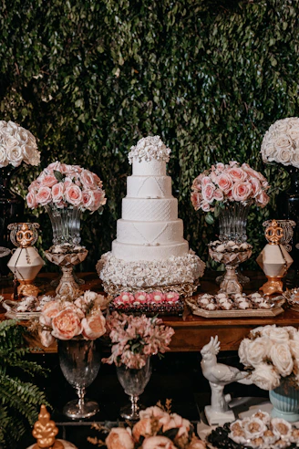 white and pink floral cake on brown wooden table