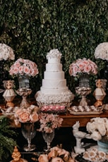 white and pink floral cake on brown wooden table