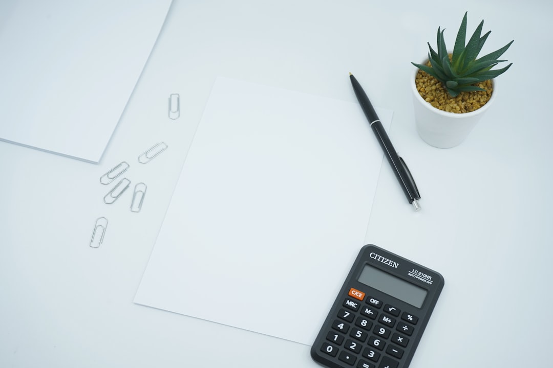 paper on a desk next to a pen and calculator.