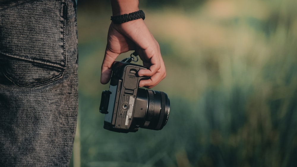 person holding black dslr camera