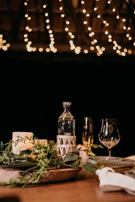 An intimate engagement setup featuring a candlelit table with delicate greenery and gold accents.