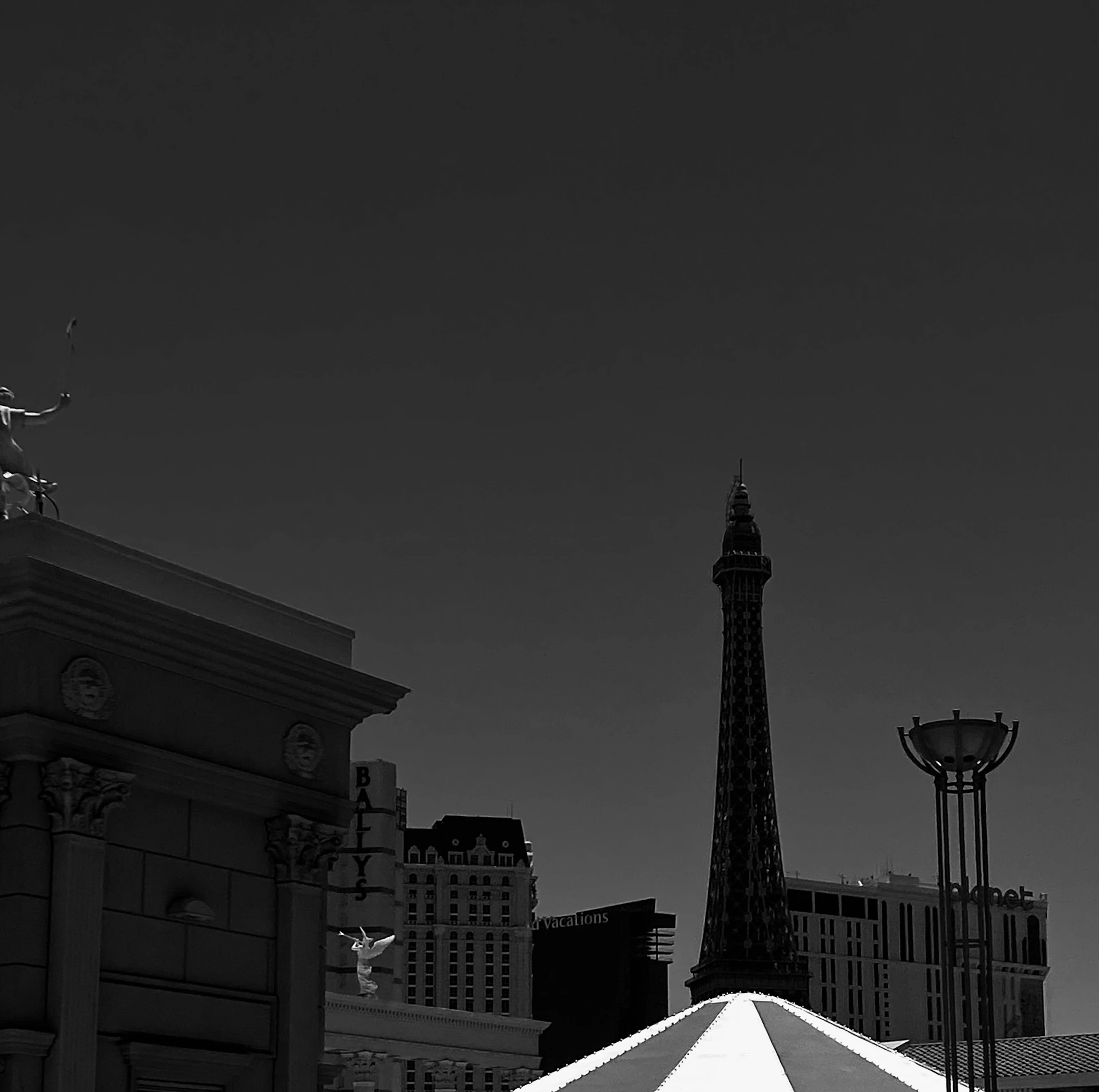 An artistic black and white cityscape with dynamic shadows and architectural details.