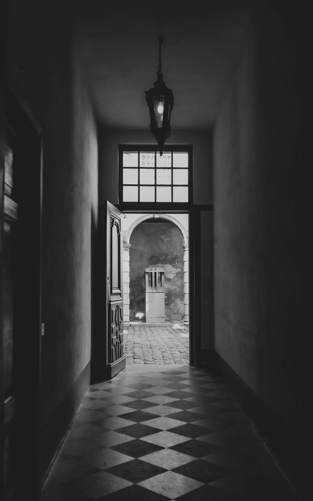 grayscale photo of hallway with arch shaped windows