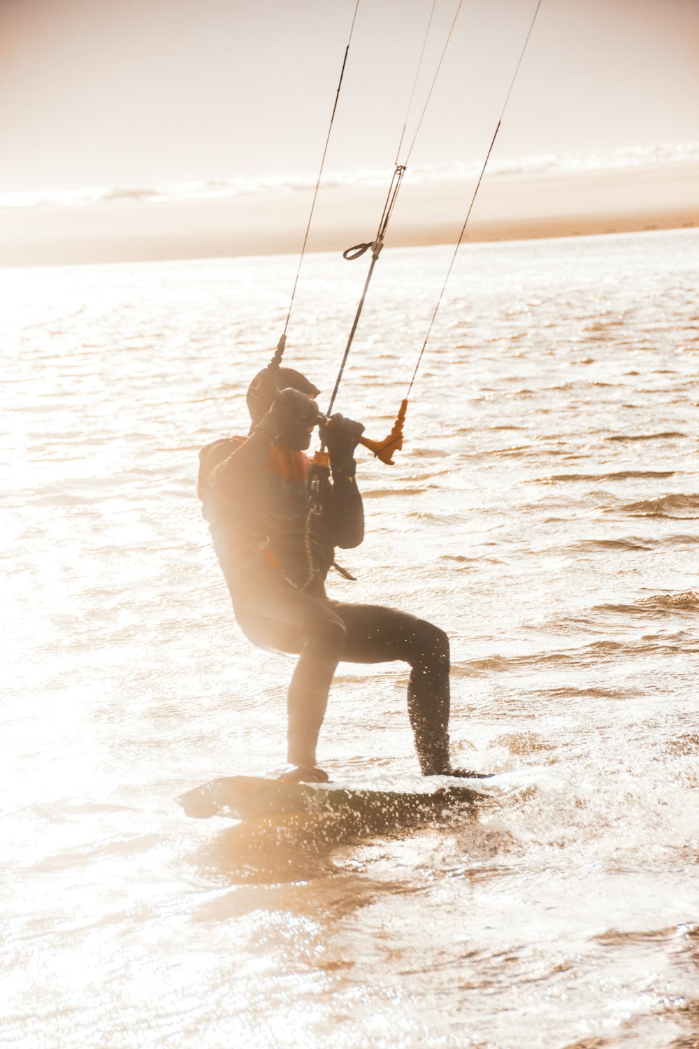 woman in black pants and black boots sitting on swing on water during daytime