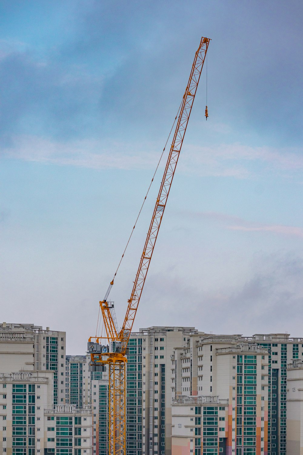 orange crane near white concrete building during daytime