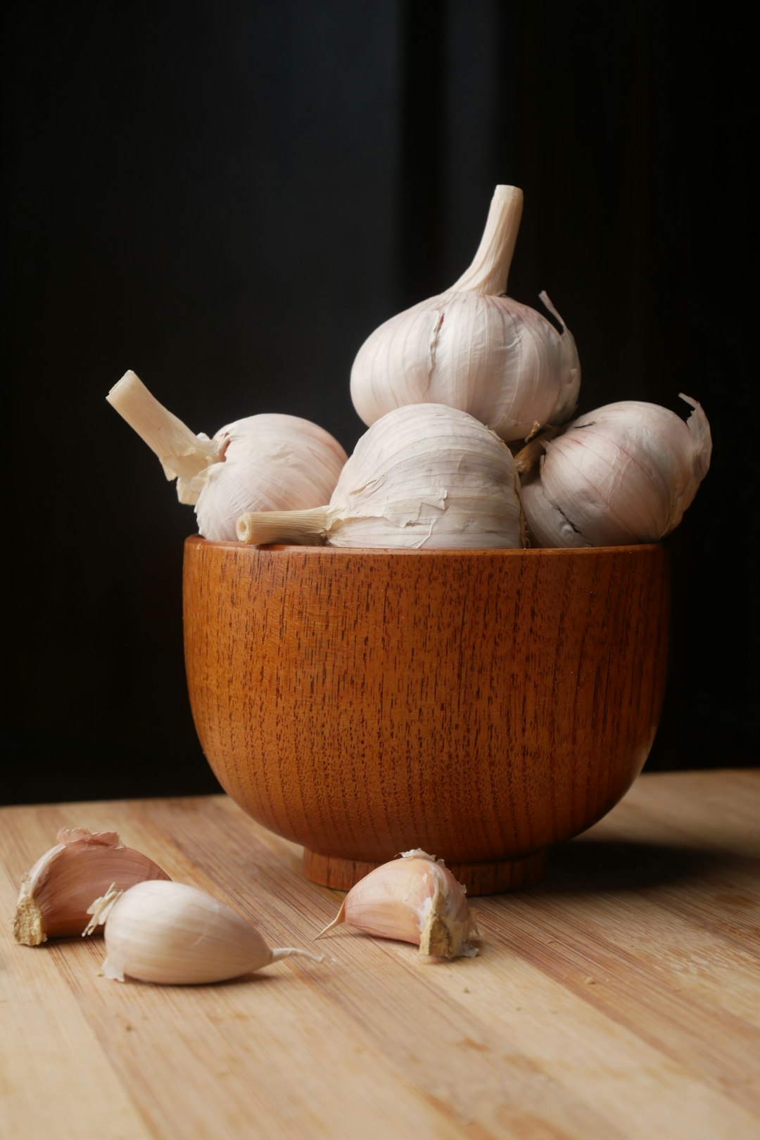 garlic on brown wooden bowl