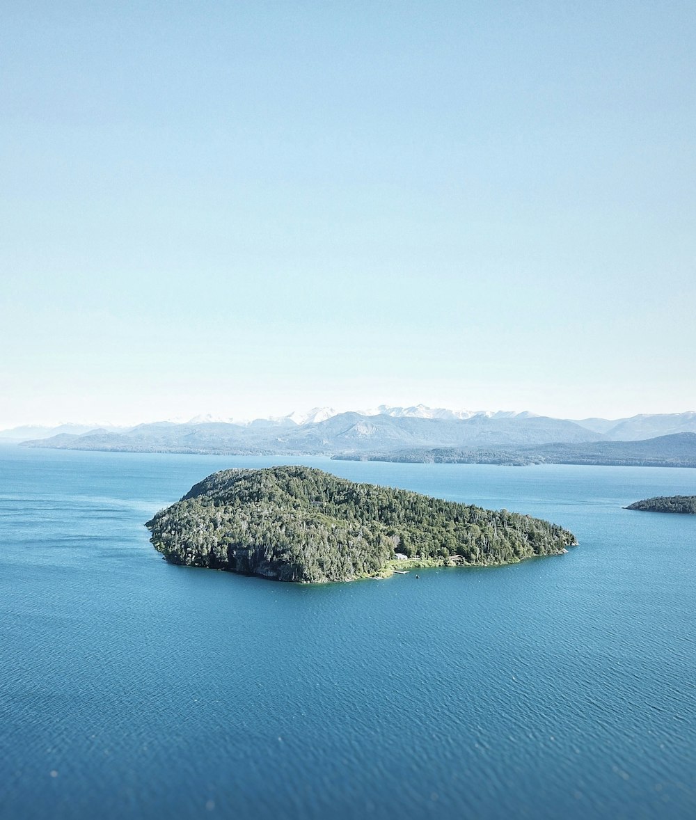 green and brown island on blue sea under white sky during daytime