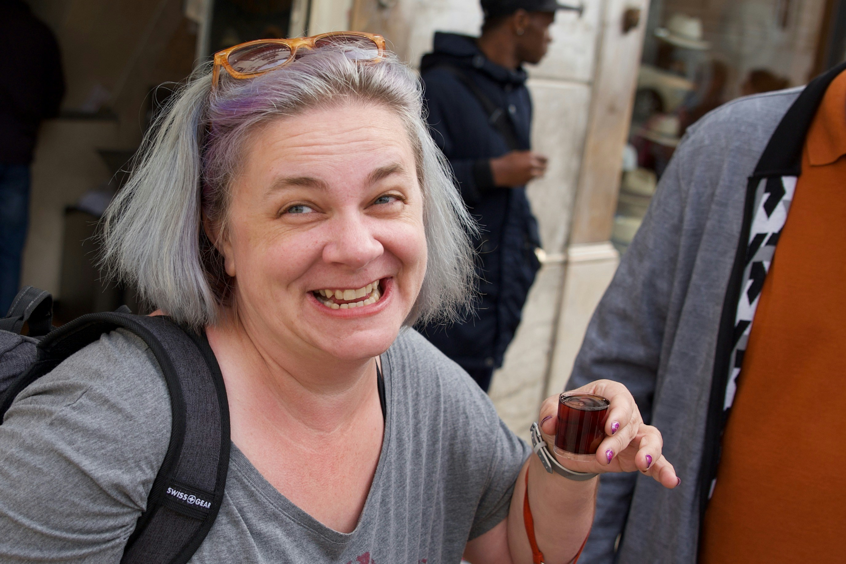 Lady holding a shot of ginjinha (Portuguese liqueur)
