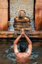 woman in water with brown concrete statue