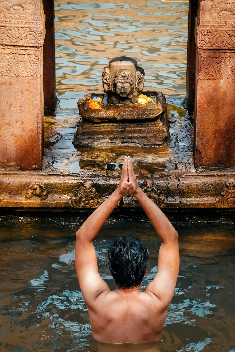 Mujer en el agua con estatua de hormigón marrón