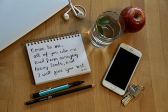 A set of keys on a table next to a checklist and smartphone.