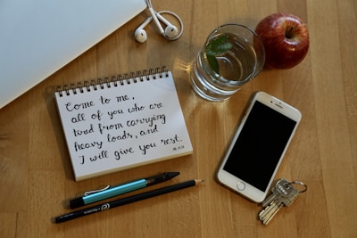 A set of keys on a table next to a checklist and smartphone.