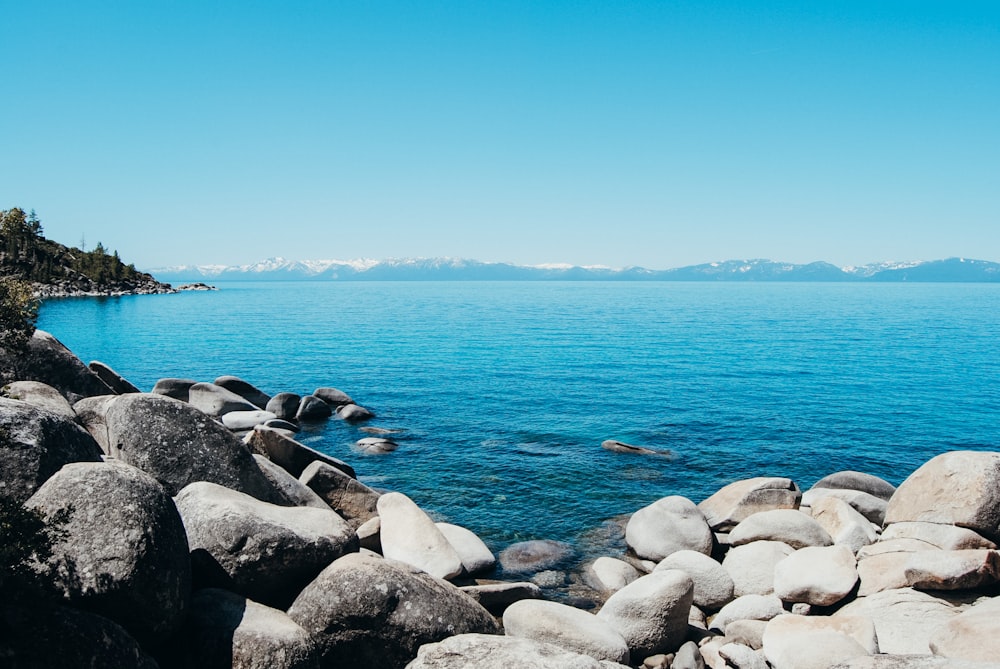 gray rocks near body of water during daytime