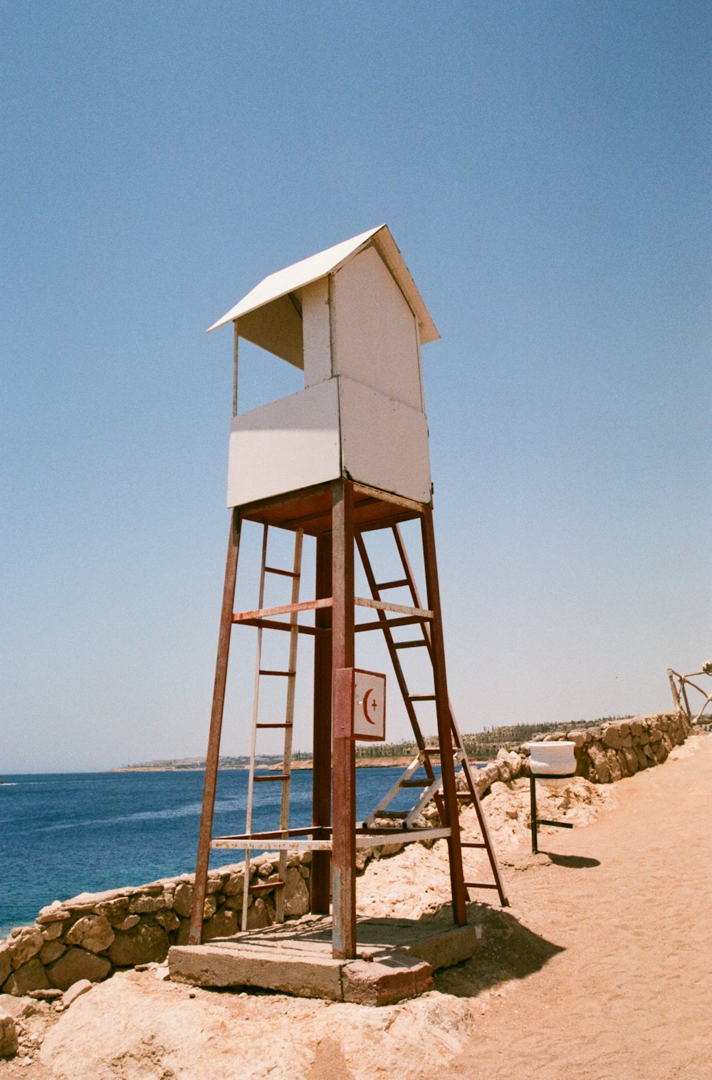 brown wooden lifeguard tower on brown sand near body of water during daytime