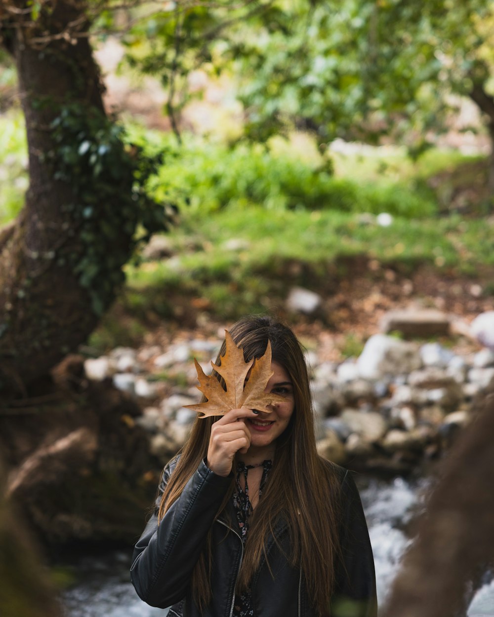 woman in black leather jacket covering her face with her hair