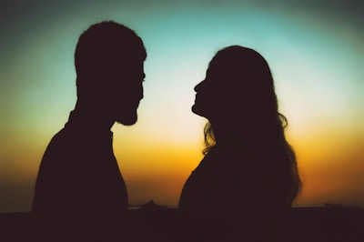 silhouette of man and woman standing during sunset