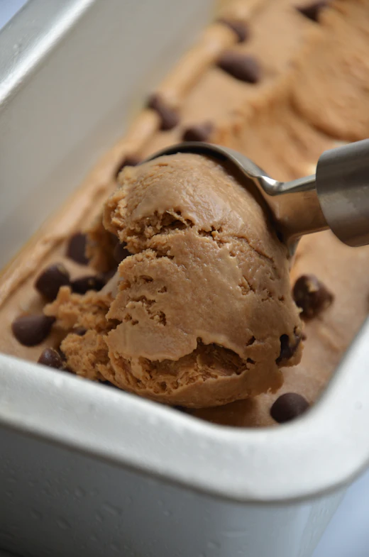 Brown butter caramel ice cream with cookie pieces being scooped