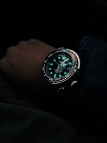 person wearing black and silver chronograph watch