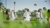man in white thobe standing on green grass field during daytime