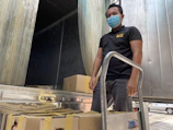 A courier wearing HIPAA and bloodborne pathogen certified gear loading supplies into a vehicle.