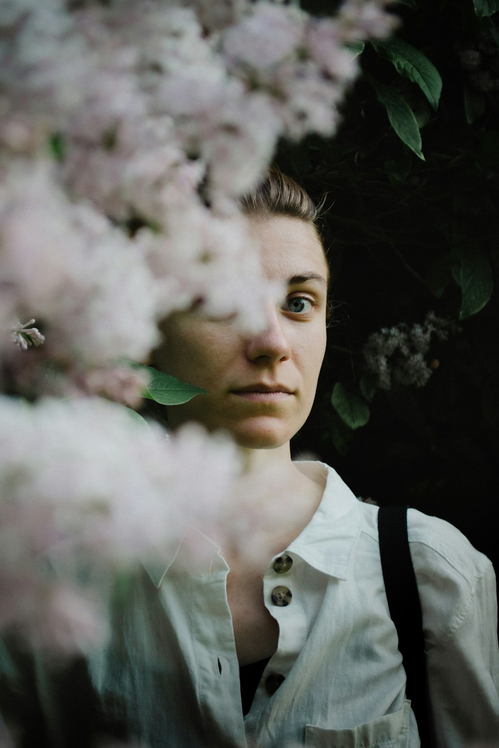 woman in white shirt standing near white flower