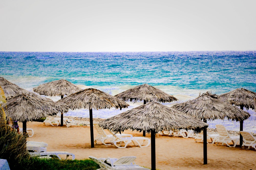 brown wooden beach umbrellas on beach shore during daytime