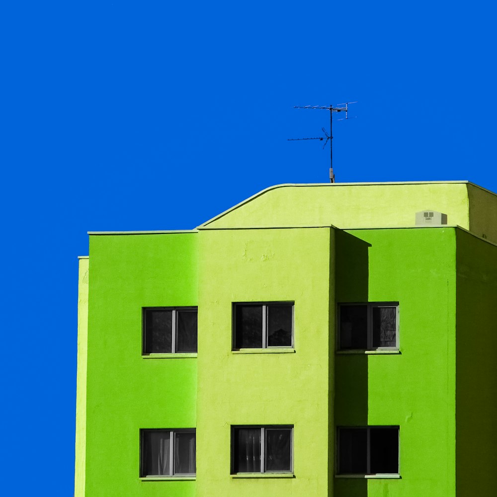 Edificio di cemento verde sotto cielo blu durante il giorno